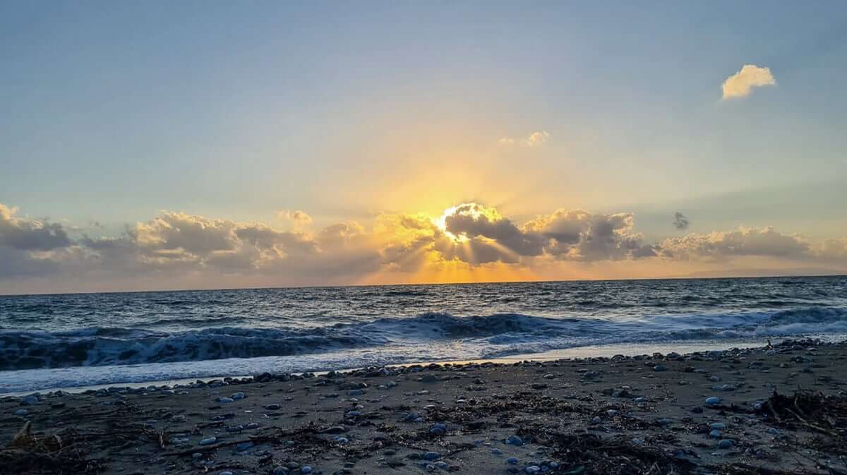 Sonnenuntergang am Meer in der Mani mit Wellen am Strand